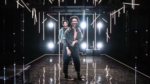 A couple of actors on stage smiling at the camera.