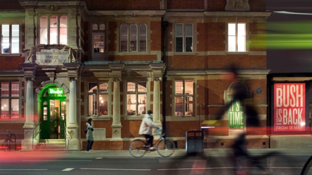 exterior of bush taken at night time, there is an image blur that shows the moving traffic on the road.