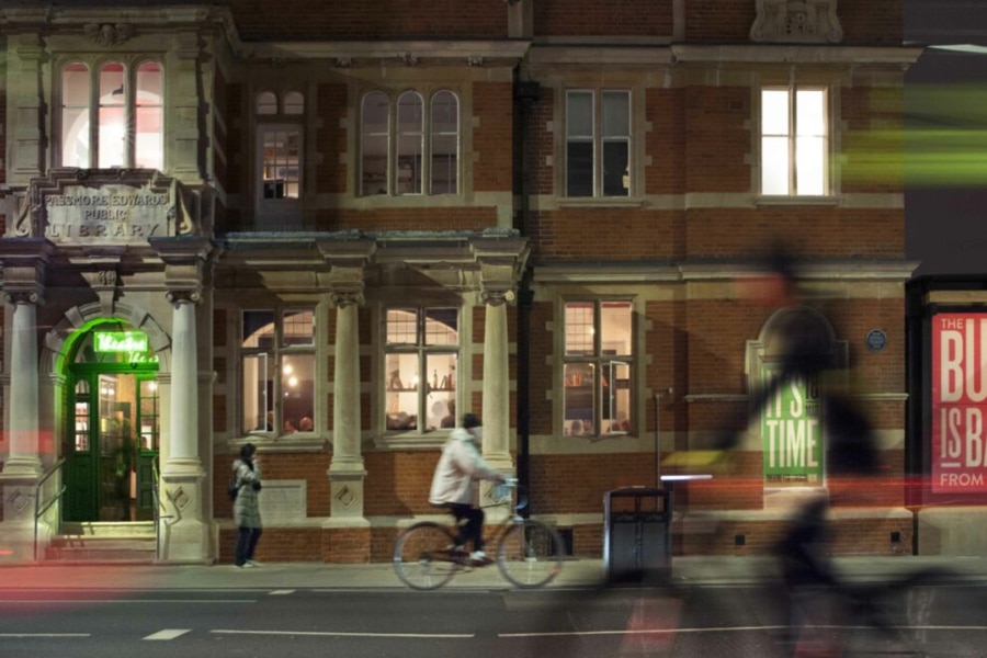 exterior of bush taken at night time, there is an image blur that shows the moving traffic on the road.