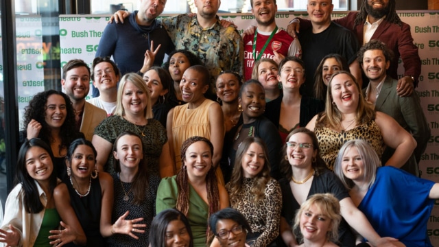Group of staff from Bush Theatre all sat together smiling at the camera