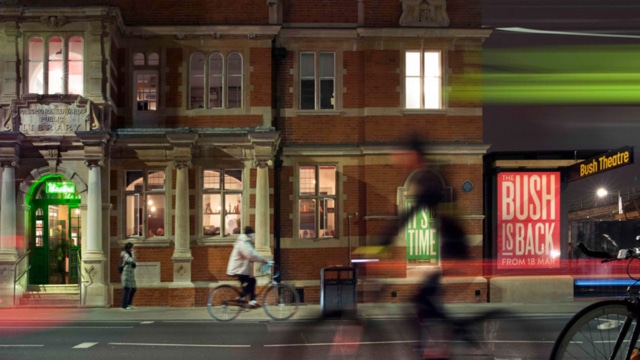 An image of the street outside the Bush Theatre. There are many people walking past and riding bicycles.