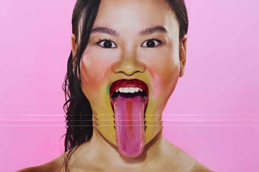 An east Asian woman looks directly at the camera with her tongue out. The image is sliced and repeated so her tongue appears really long.