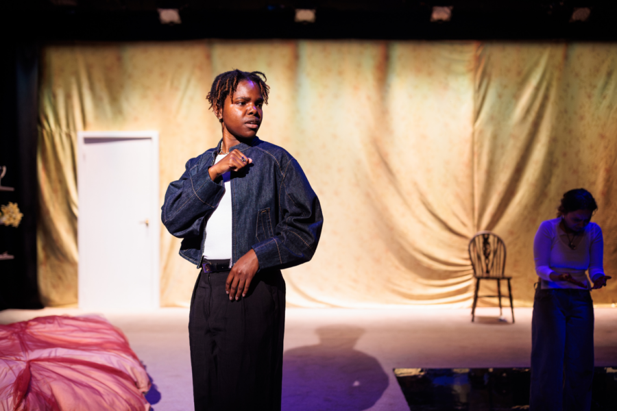Production photo: Francesca Amewudah-Rivers wears a denim jacket and looks to the side.
