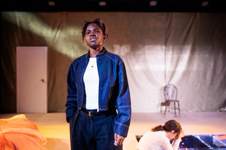 Production photo: Francesca Amewudah-Rivers wears a denim jacket and looks ahead/